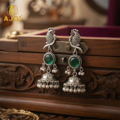 Handcrafted Antique Silver Peacock Jhumka Earrings with Emerald Green Stone & Pearl Drop Detailing